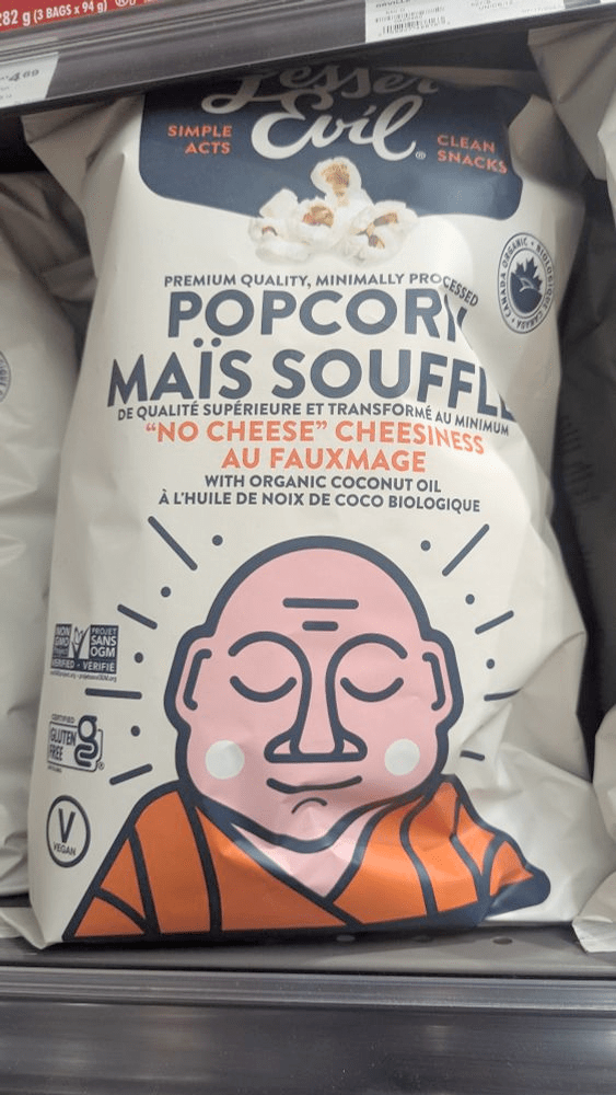 A bag of popcorn labeled in French and English. Where the English says "No cheese cheesiness," the French says "Au fauxmage"